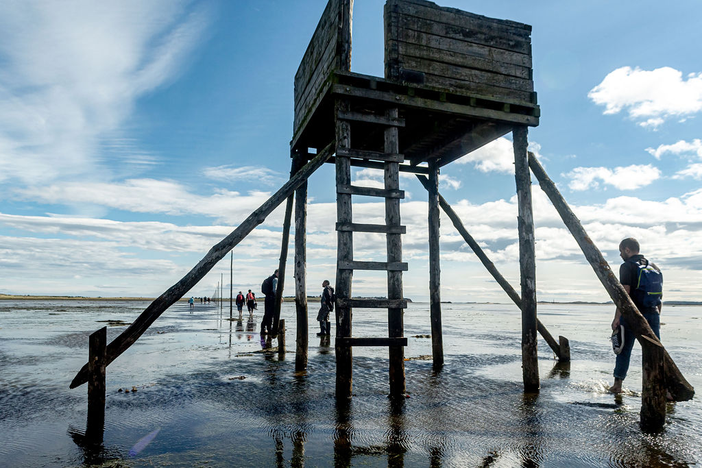 People walking past a refuge tower on the Pilgrim’s Way.